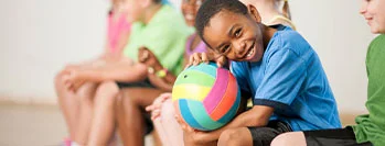 The child holds the ball